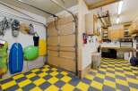 This garage boasts a unique yellow and gray checkered floor, offering a stylish and functional space.