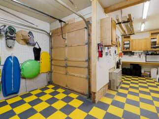 This garage boasts a unique yellow and gray checkered floor, offering a stylish and functional space.