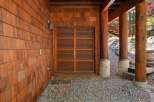 This stunning property boasts a beautiful wooden garage door, complemented by the warmth of cedar shake siding.