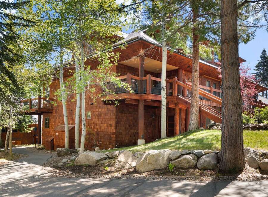 Nestled amidst lush greenery, this stunning property boasts a unique architectural design with cedar siding and multiple levels.