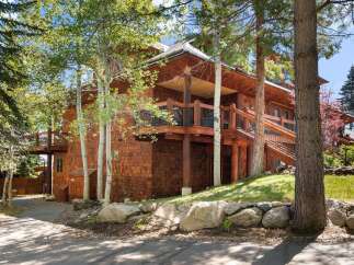 Nestled amidst lush greenery, this stunning property boasts a unique architectural design with cedar siding and multiple levels.