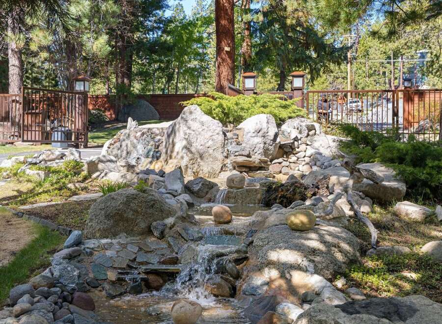Discover a serene oasis in this stunning property, featuring a beautifully designed rock waterfall.
