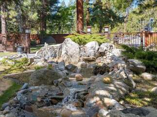 Discover a serene oasis in this stunning property, featuring a beautifully designed rock waterfall.
