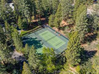 Nestled amidst a lush forest, this property boasts a private tennis court, perfect for active living and outdoor recreation.