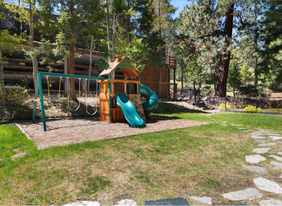 Discover the perfect family retreat with this stunning property! Featuring a charming playground with swings and a slide, it's an ideal space for kids to play and enjoy the outdoors.