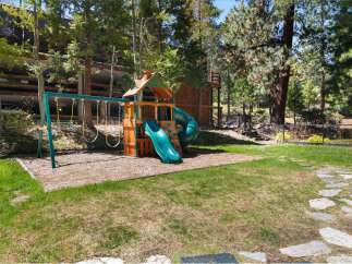 Discover the perfect family retreat with this stunning property! Featuring a charming playground with swings and a slide, it's an ideal space for kids to play and enjoy the outdoors.