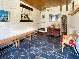 Step into this inviting entryway, featuring a unique slate tile floor and a charming wooden bench.