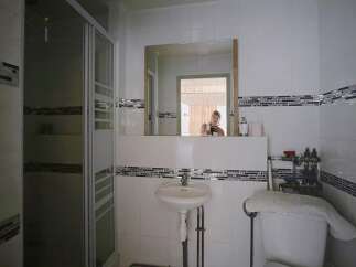 Discover this charming bathroom featuring a sleek glass shower enclosure and a stylish sink.