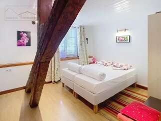 Discover this charming bedroom featuring a cozy bed and a touch of elegance.