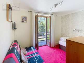 This charming property features a cozy living space with a vibrant pink carpet and a comfortable sofa.