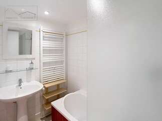 This bright bathroom features a modern design with white tiles and a sleek sink.