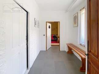 Step into this inviting entryway, featuring a charming wooden bench and a glimpse into the adjacent rooms.