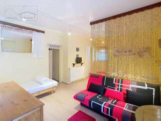 Discover this charming property featuring a cozy living space with a stylish red and black sofa.