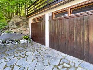 Discover this charming property featuring a unique stone pathway leading to a rustic wooden garage.
