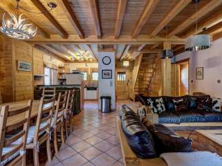Step into rustic elegance with this stunning chalet! Featuring a warm, inviting interior with exposed wooden beams and a cozy living area, perfect for relaxing.