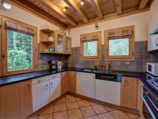 This charming kitchen boasts a rustic design with wooden cabinets and a tiled floor, creating a warm and inviting atmosphere.