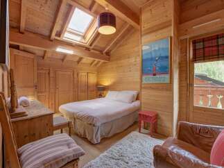 This cozy bedroom features a warm, inviting atmosphere with its wooden walls and ceiling.