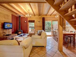 Step into this cozy cabin retreat, featuring a warm and inviting living space with a fireplace and comfortable seating.