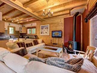 Step into this cozy chalet, featuring a warm wooden interior and a welcoming fireplace.
