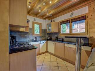 This charming kitchen boasts a rustic ambiance with its wooden ceiling and cabinetry.