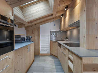 This stunning kitchen boasts a rustic charm with its wooden cabinetry and exposed beams, creating a warm and inviting atmosphere.