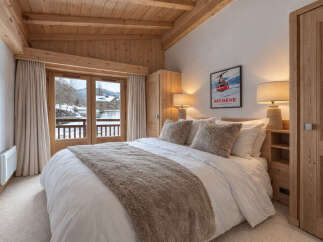 Experience the charm of this cozy bedroom, featuring a warm wooden ceiling and a comfortable bed.