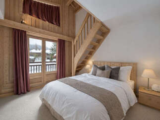 This cozy bedroom features a unique wooden design with a charming staircase leading to an upper level.