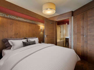 This cozy bedroom features a warm, inviting ambiance with its wooden paneling and soft lighting.