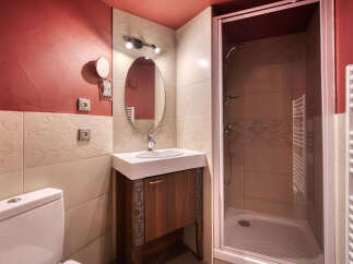 This bathroom features a stylish design with a red accent wall and patterned tiles.