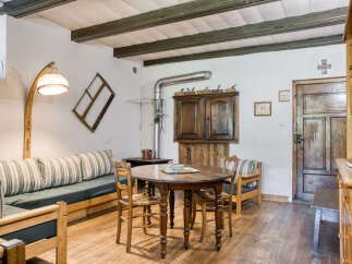 Step into this charming rustic home, featuring a cozy living space with a unique wooden sofa and a vintage-style lamp.