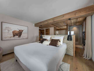 Experience luxury in this stunning bedroom featuring a king-size bed, elegant decor, and a captivating artwork.