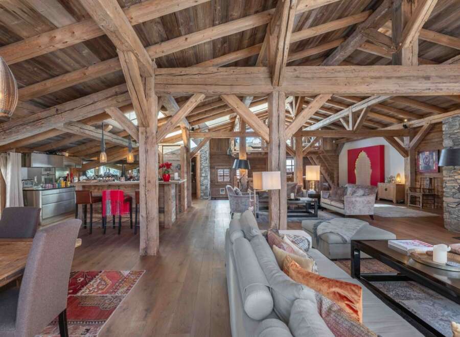 Experience luxury living in this stunning chalet, showcasing exposed wooden beams and a spacious open floor plan.