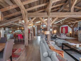 Experience luxury living in this stunning chalet, showcasing exposed wooden beams and a spacious open floor plan.