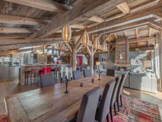 Experience luxury living in this stunning chalet, showcasing exquisite wooden beams and a cozy fireplace.
