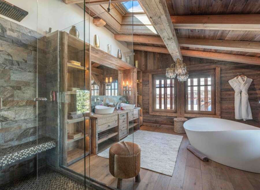Experience luxury in this stunning bathroom featuring a rustic wooden design and a modern freestanding bathtub.