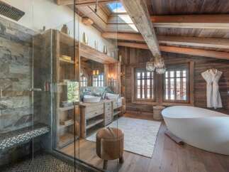 Experience luxury in this stunning bathroom featuring a rustic wooden design and a modern freestanding bathtub.