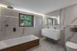 This stunning bathroom boasts a modern design with luxurious marble finishes and a sleek, minimalist aesthetic.