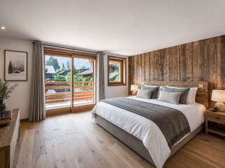 Experience luxury in this stunning bedroom featuring a rustic wooden accent wall and a cozy king-sized bed.