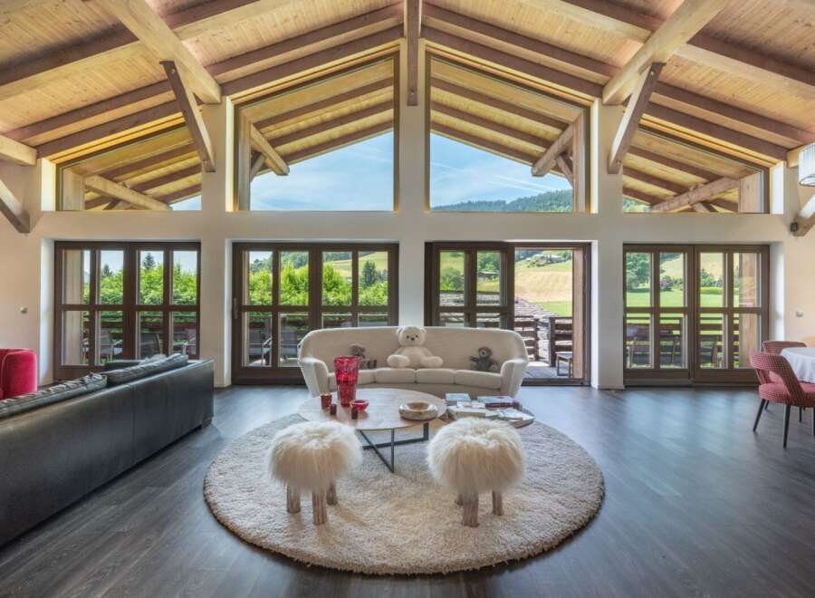 Experience luxury living in this stunning property, featuring a spacious living area with expansive windows that offer breathtaking views of the surrounding landscape.