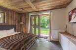 Experience rustic charm in this cozy bedroom, featuring a warm wooden ceiling and walls.