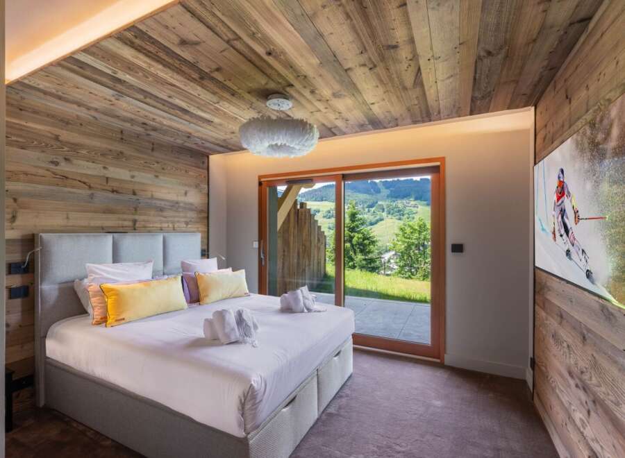 Experience luxury living in this stunning bedroom featuring a cozy wooden ceiling and walls.