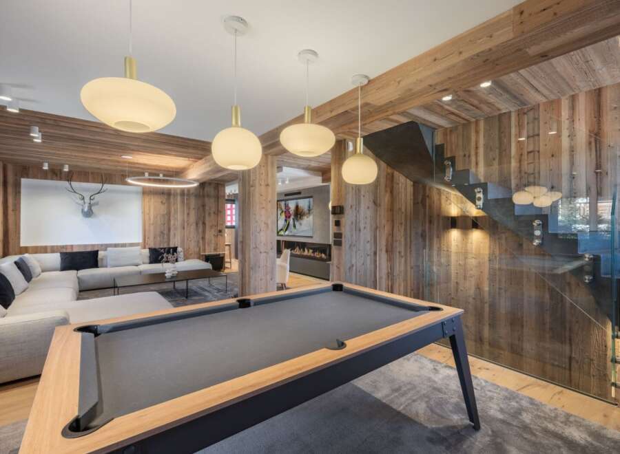 Experience luxury living in this stunning property featuring a modern pool table and a cozy living area.