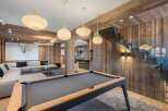 Experience luxury living in this stunning property featuring a modern pool table and a cozy living area.