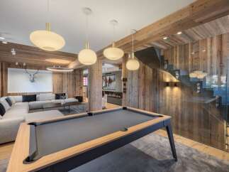 Experience luxury living in this stunning property featuring a modern pool table and a cozy living area.
