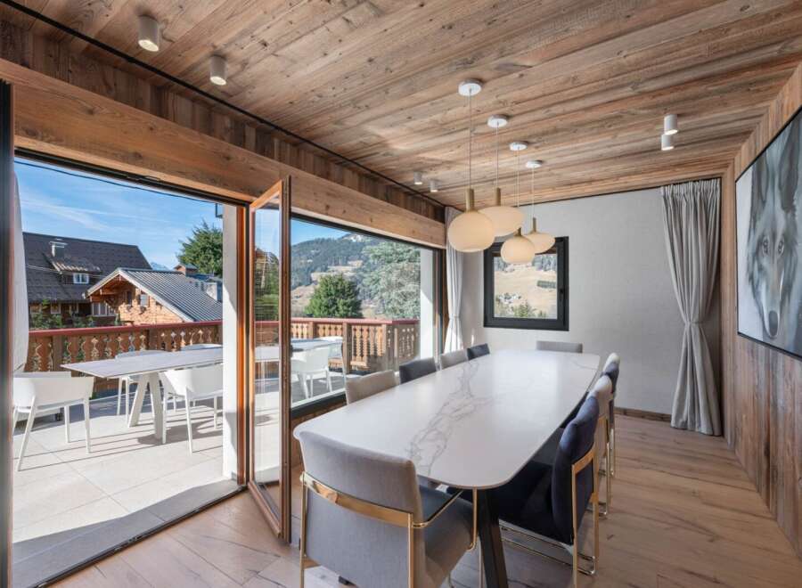 Experience luxury living in this stunning dining room, featuring a modern marble table and stylish chairs.