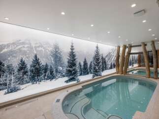 Indulge in luxury with this stunning indoor pool, featuring a breathtaking mountain mural that creates a serene and immersive atmosphere.