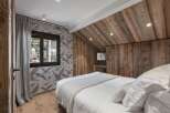 This cozy bedroom features a rustic wooden ceiling and walls, creating a warm and inviting atmosphere.