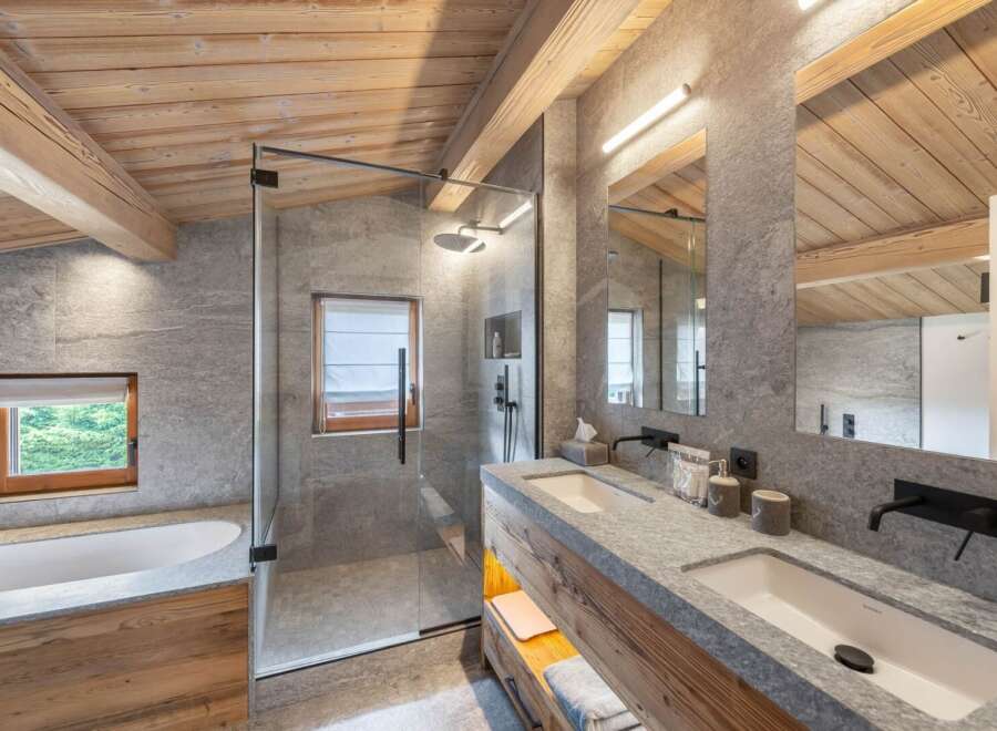 Experience luxury in this stunning bathroom featuring a sleek glass shower, dual sinks, and a modern design.