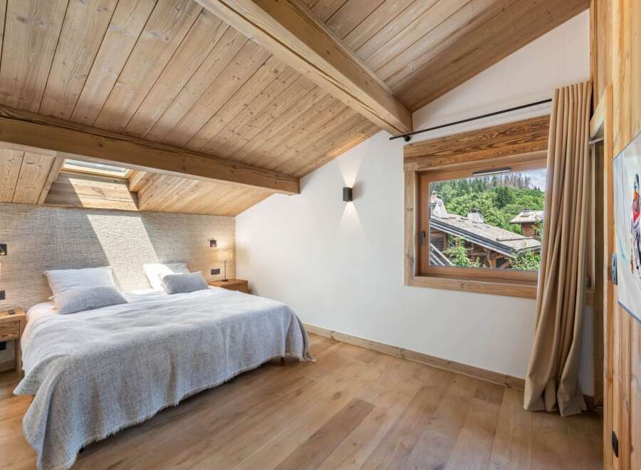 Experience the charm of this stunning bedroom, featuring a warm wooden ceiling and flooring that create a cozy atmosphere.