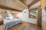 Experience the charm of this stunning bedroom, featuring a warm wooden ceiling and flooring that create a cozy atmosphere.